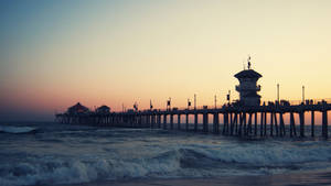 A Pier With A Lighthouse Wallpaper