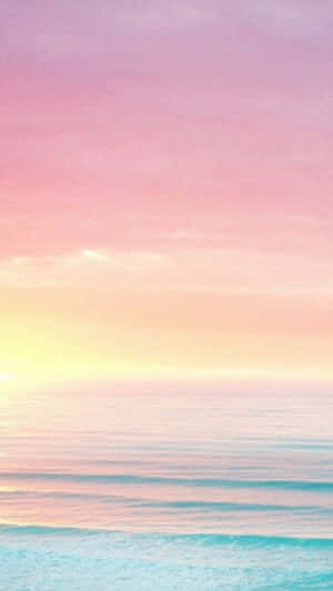 A Pink And Purple Sunset Over The Ocean Wallpaper