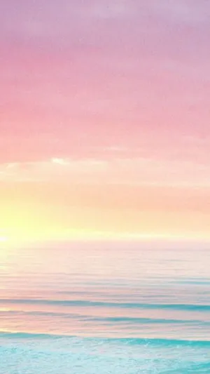 A Pink And Purple Sunset Over The Ocean Wallpaper
