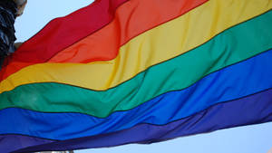 A Rainbow Flag Is Flying In The Wind Wallpaper