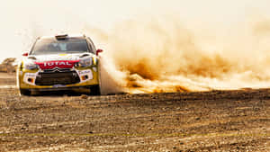 A Rally Car Driving Through A Dusty Area Wallpaper