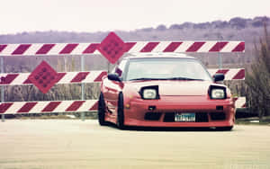 A Red Car Is Parked In Front Of A Fence Wallpaper