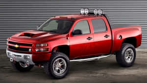 A Red Chevrolet Silverado Truck Is Parked In Front Of A Garage Wallpaper