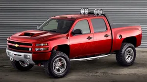 A Red Chevrolet Silverado Truck Is Parked In Front Of A Garage Wallpaper