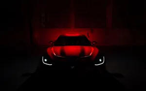 A Red Sports Car Is Lit Up In The Dark Wallpaper
