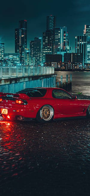 A Red Sports Car Parked In A City Wallpaper