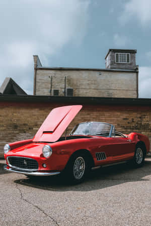 A Red Sports Car Parked In Front Of A Building Wallpaper