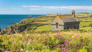 A Small Building On A Hillside Wallpaper