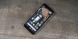 A Smartphone Is Sitting On A Wooden Table Wallpaper