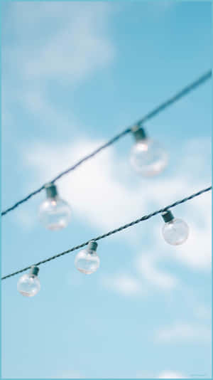 A String Of Lights With Blue Sky Behind Them Wallpaper