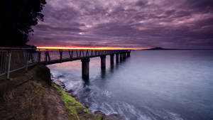 A Stunning Laptop On A Bridge At Twilight Wallpaper