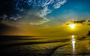 A Sunrise Reflection On A Dark Beach Wallpaper