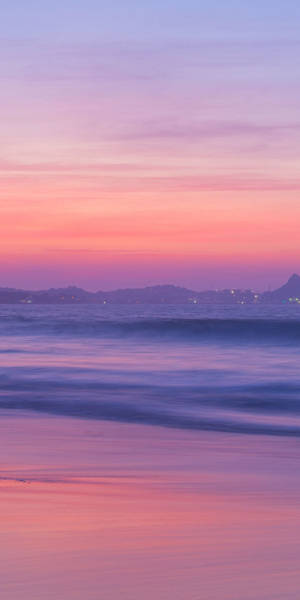 A Sunset With A Pink Sky And Water Wallpaper