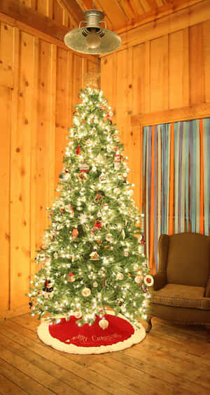 A Tranquil Christmas Tree Adorns A Room, Creating A Cozy And Peaceful Atmosphere. Wallpaper