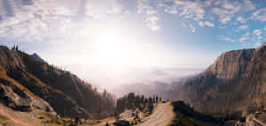 A View Of A Mountain With Trees And Mountains Wallpaper