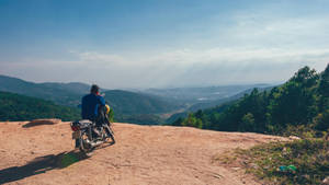 A View Of An Open Travel Laptop With An Expanse Of A City Mountain View In The Background Wallpaper