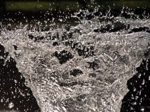 A Water Fountain With Water Splashing Out Of It Wallpaper
