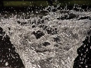 A Water Fountain With Water Splashing Out Of It Wallpaper