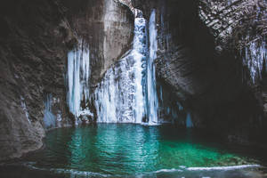 A Waterfall Cascading Over A Pool, Creating The Perfect Atmosphere For Calm Reflection. Wallpaper