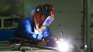 A Welder Working On A Metal Piece Wallpaper