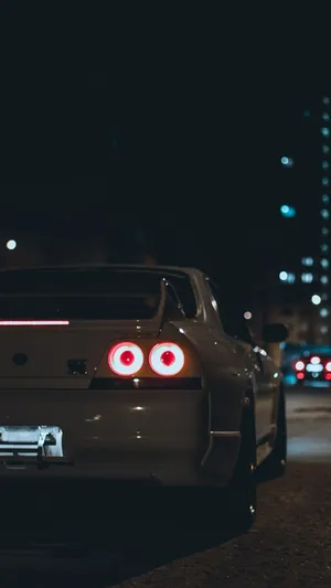 A White Car With Red Lights On The Road At Night Wallpaper