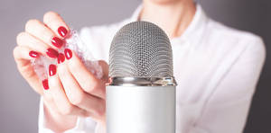 A Woman Holding A Microphone With Her Nails On It Wallpaper