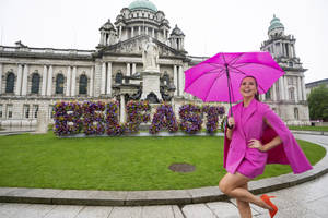 A Woman In Pink Standing In Front Of A Building Wallpaper