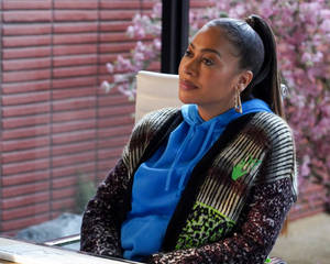 A Woman Sitting At A Desk With A Laptop Wallpaper