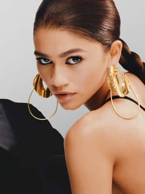 A Woman Wearing Gold Earrings And A Black Top Wallpaper