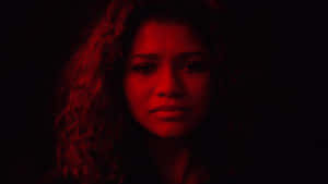 A Woman With Curly Hair In A Dark Room Wallpaper