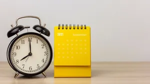 A Yellow Alarm Clock Next To A Calendar Wallpaper