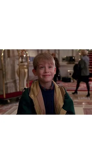 A Young Boy In A Green Jacket Is Smiling Wallpaper