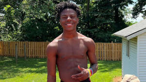 A Young Man In A Swimsuit Standing In A Yard Wallpaper