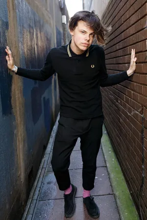 A Young Man In Black Standing In A Alleyway Wallpaper