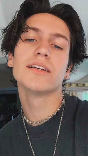 A Young Man With Long Hair And A Necklace Wallpaper