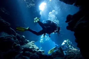 Adventurous Scuba Diving In Mesmerizing Underwater Cavern Wallpaper