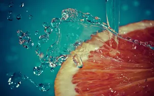 Aesthetic Sliced Grapefruit Water Splash Wallpaper