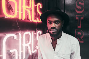 African Man Standing Beside Led Signage Wallpaper