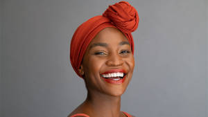 African Woman Wearing Orange Headscarf Wallpaper