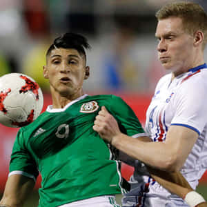 Alan Pulido Challenging The Spain Defender During An International Soccer Match Wallpaper