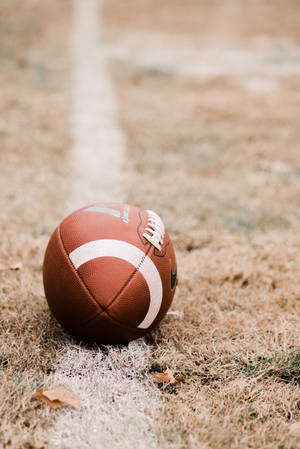 American Football On Brown Grass Wallpaper