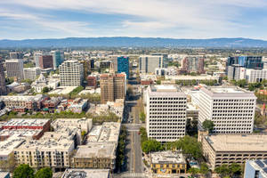 An Aerial View Of A City With Tall Buildings And Trees Wallpaper