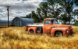 An Old Truck In A Field Wallpaper