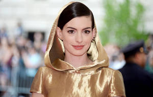 Anne Hathaway In A Glamorous Golden Robe Wallpaper