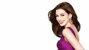 Anne Hathaway In A Stunning Purple Dress Smiling For The Camera Wallpaper