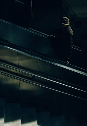 Anonymous Man Riding An Escalator Wallpaper