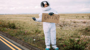 Astronaut Holding Sign Board Photography Wallpaper