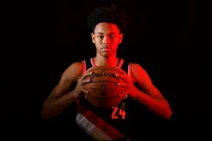 Basketball Player Holding Ball Dark Background Wallpaper