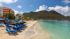 Beach Chairs In Sint Maarten's Shoreline Wallpaper