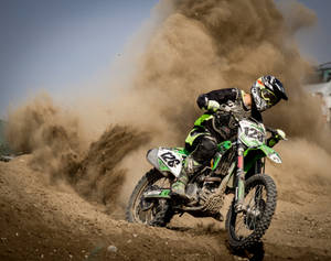 Bike Rider With Dirt Clouds Behind Him Wallpaper